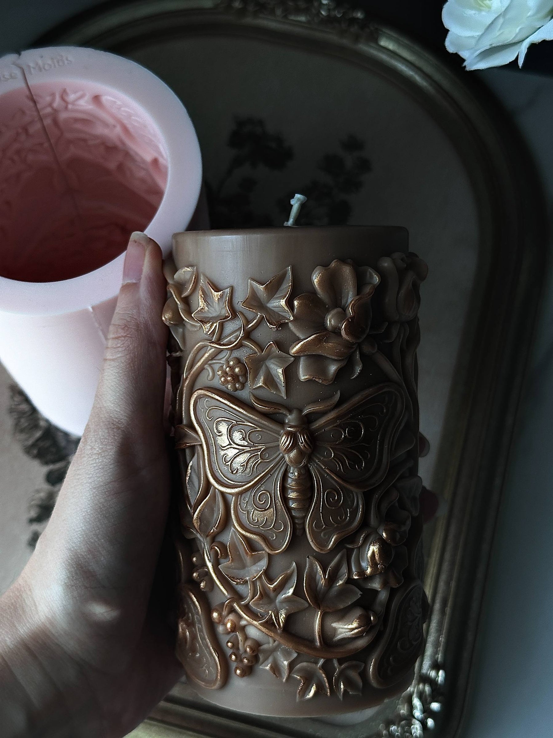large moth pillar candle made with silicone candle mold on vintage tray
